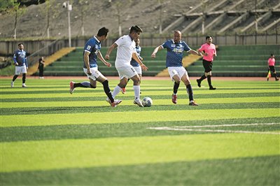 右图：4月11日，云岩队球员（白色球衣）和花溪队球员在比赛中拼抢。 贵阳日报融媒体记者 徐坚 摄